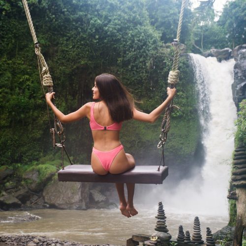 Mulher em baloiço em Tegenungan Waterfall, Bali